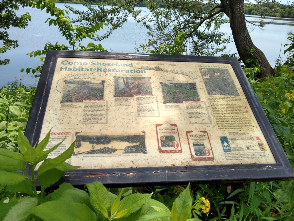 A faded, weathered informational sign titled 